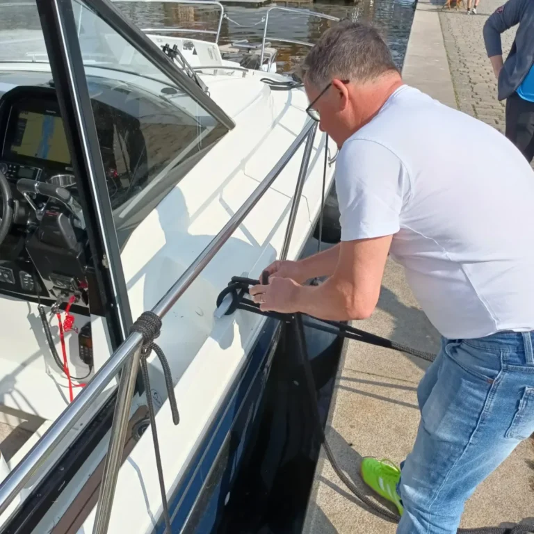 Účastník kapitánského kurzu za kormidlem na Vltavě